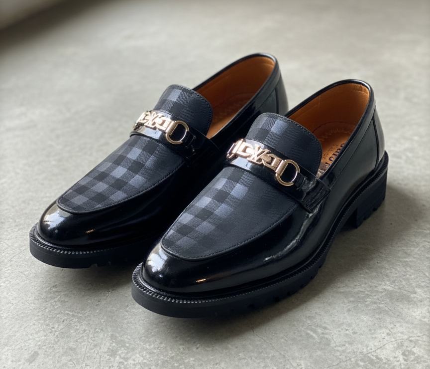 Pair of black checkered loafers on a light gray floor.